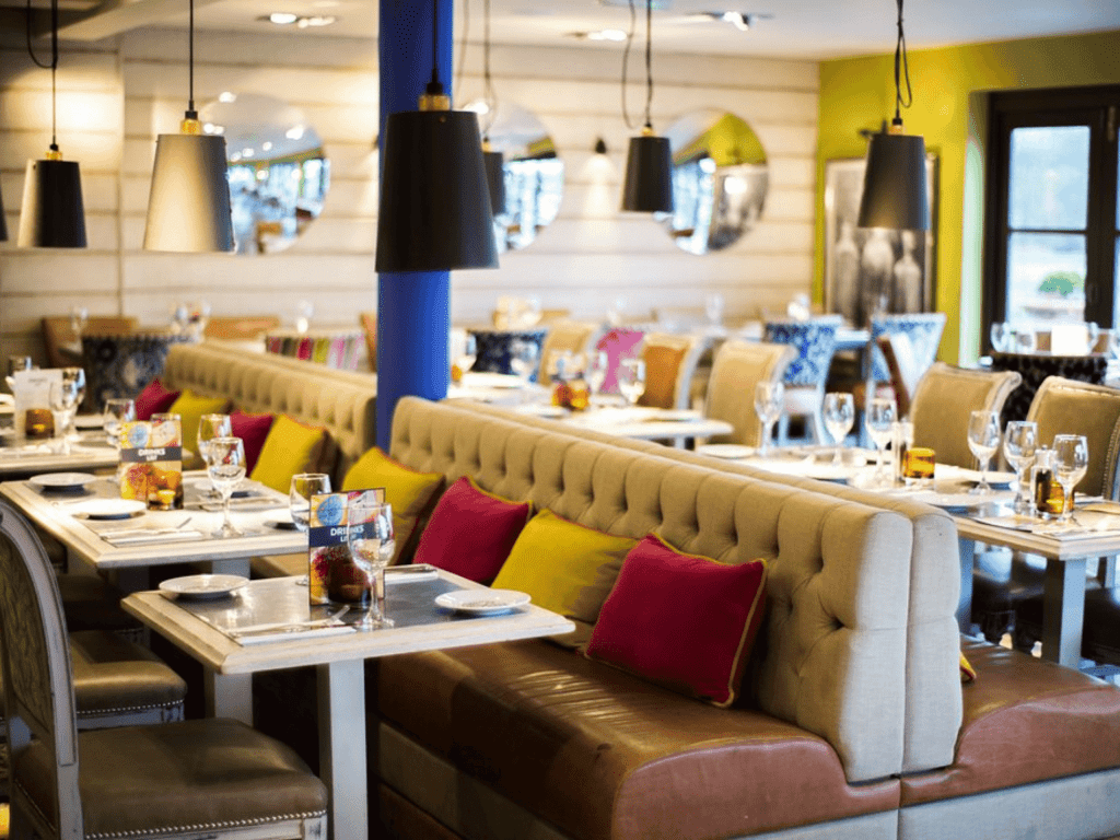 Interior of a traditional country pub featuring bespoke pub furniture including dining chairs, bar stools, and tables to enhance the vibrant yet traditional charm of the pub.