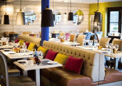 Interior of a traditional country pub featuring bespoke pub furniture including dining chairs, bar stools, and tables to enhance the vibrant yet traditional charm of the pub.