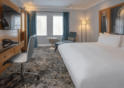 Interior of hotel rooms at Chesford Grange Hotel, featuring comfortable desk chairs, chaise longues, and tub chairs for a stylish, fresh look for this countryside retreat.