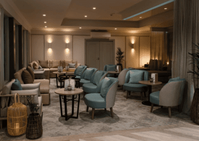 Interior of Aztec Hotel and Spa, a hotel pool and spa area, featuring relaxing and comfortable lounge day beds, lounge chairs, and sofas for a calm and serene atmosphere.