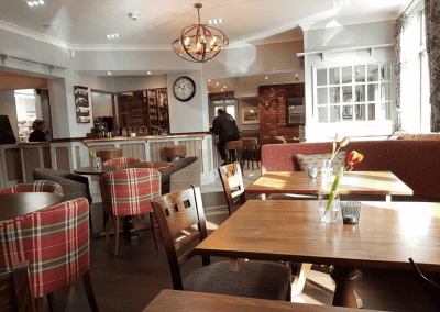 Interior of The Hollybush Inn, a family country inn featuring traditional fixed seating, dining and bar furniture, and refurbished pub furniture to enhance the heritage appeal of the pub.
