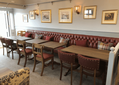 Interior of a family country inn featuring traditional fixed seating, dining and bar furniture, and refurbished pub furniture to enhance the heritage appeal of the pub.