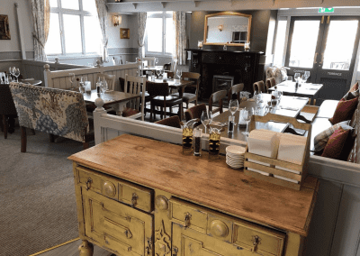 Interior of a family country inn featuring traditional fixed seating, dining and bar furniture, and refurbished pub furniture to enhance the heritage appeal of the pub.