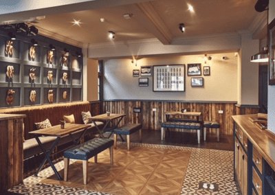 Interior of a traditional style pub featuring bespoke pub furniture including dining chairs, bar stools, and tables to retain the traditional charm of the pub.