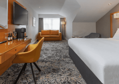 Interior of hotel rooms at Chesford Grange Hotel, featuring comfortable desk chairs, chaise longues, and tub chairs for a stylish, fresh look for this countryside retreat.