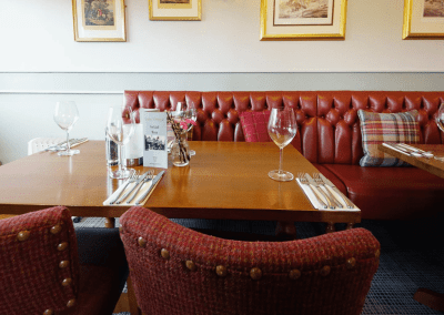 Interior of The Hollybush Inn, a family country inn featuring traditional fixed seating, dining and bar furniture, and refurbished pub furniture to enhance the heritage appeal of the pub.