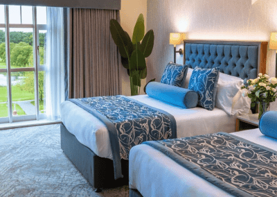 Interior of Carden Park Hotel, a luxury boutique hotel with sophisticated bedrooms, featuring bespoke headboards and furniture with elegant styling.