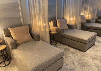 Interior of Aztec Hotel and Spa, a hotel pool and spa area, featuring relaxing and comfortable lounge day beds, lounge chairs, and sofas for a calm and serene atmosphere.