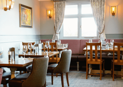 Interior of The Hollybush Inn, a family country inn featuring traditional fixed seating, dining and bar furniture, and refurbished pub furniture to enhance the heritage appeal of the pub.