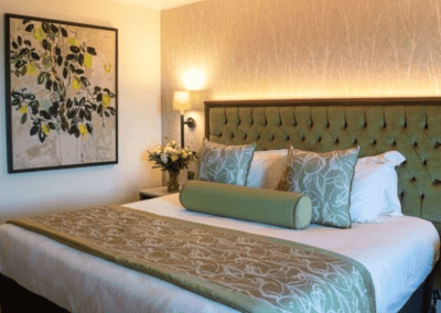 Interior of Carden Park Hotel, a luxury boutique hotel with sophisticated bedrooms, featuring bespoke headboards and furniture with elegant styling.