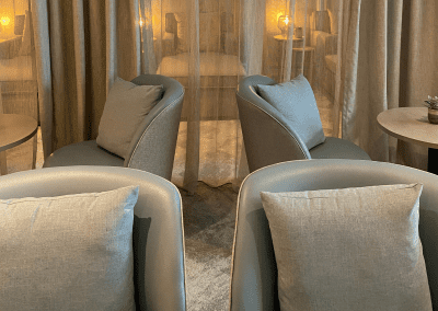 Interior of Aztec Hotel and Spa, a hotel pool and spa area, featuring relaxing and comfortable lounge day beds, lounge chairs, and sofas for a calm and serene atmosphere.