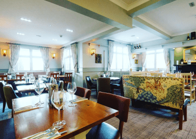 Interior of The Hollybush Inn, a family country inn featuring traditional fixed seating, dining and bar furniture, and refurbished pub furniture to enhance the heritage appeal of the pub.