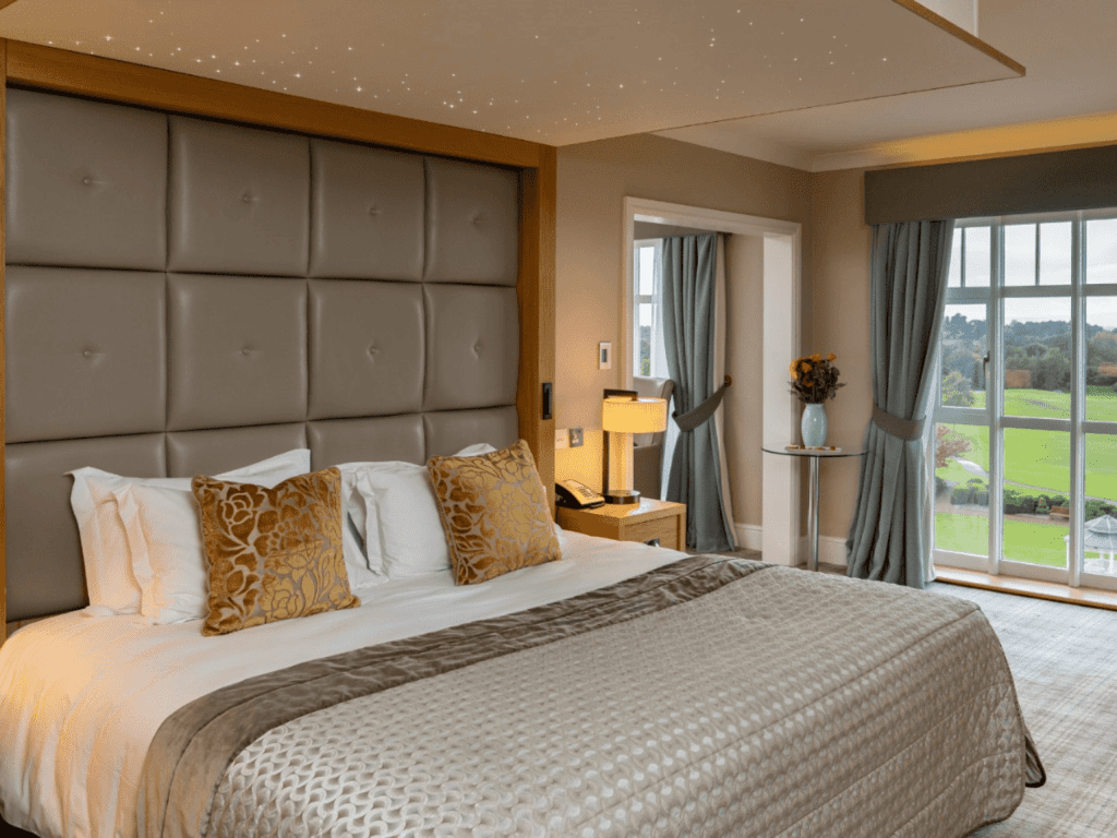 Interior of a luxury boutique hotel with sophisticated bedrooms, featuring bespoke headboards and furniture with elegant styling.