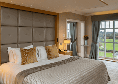 Interior of a luxury boutique hotel with sophisticated bedrooms, featuring bespoke headboards and furniture with elegant styling.