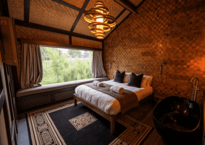 Interior of a selection of safari inspired lodges with vibrant bedrooms, featuring bespoke curtains and soft furnishings with elegant styling.