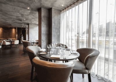 Bespoke wave voile curtains at a Michelin star restaurant, enhancing the modern and elegant interior with tailored soft furnishings.