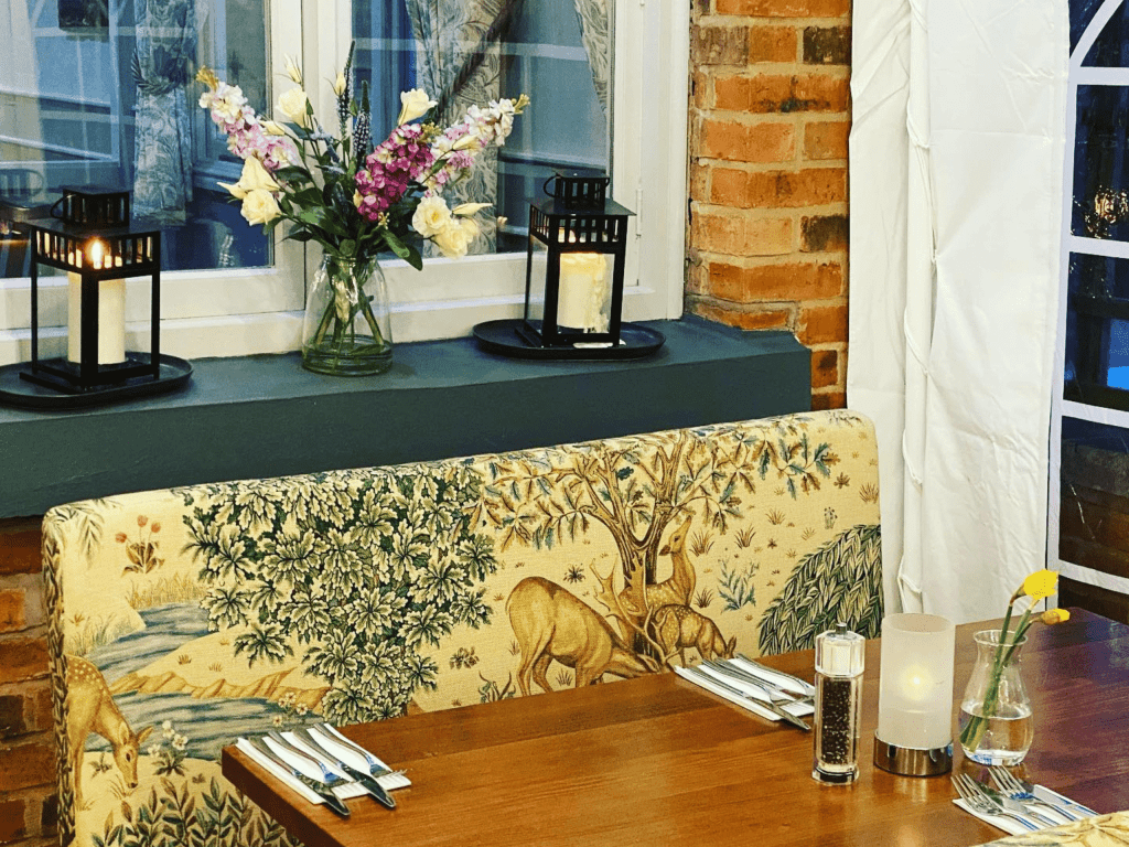 Interior of The Hollybush Inn, a family country inn featuring traditional fixed seating, dining and bar furniture, and refurbished pub furniture to enhance the heritage appeal of the pub.