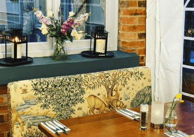 Interior of The Hollybush Inn, a family country inn featuring traditional fixed seating, dining and bar furniture, and refurbished pub furniture to enhance the heritage appeal of the pub.