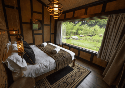 Interior of a selection of safari inspired lodges with vibrant bedrooms, featuring bespoke curtains and soft furnishings with elegant styling.