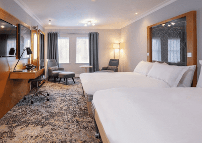 Interior of hotel rooms, featuring comfortable desk chairs, chaise longues, and tub chairs for a stylish, fresh look for this countryside retreat.