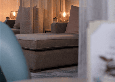 Interior of a hotel pool and spa area, featuring relaxing and comfortable lounge day beds, lounge chairs, and sofas for a calm and serene atmosphere.
