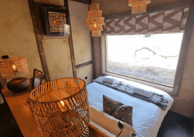 Interior of a selection of safari inspired lodges with vibrant bedrooms, featuring bespoke curtains and soft furnishings with elegant styling.