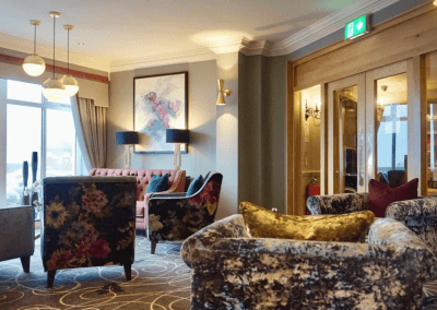 Interiors of a coastal hotel featuring contract furniture, lounge seating, bedroom furniture, and bespoke curtains, pelmets, and blinds reflecting the hotel’s vibrant coastal design.