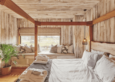 Interior of a selection of safari inspired lodges with vibrant bedrooms, featuring bespoke curtains and soft furnishings with elegant styling.