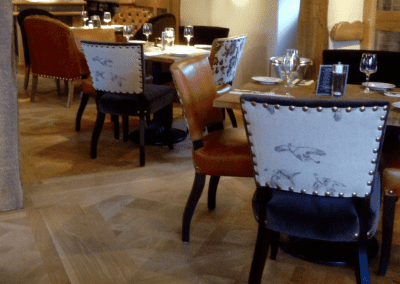 Interior of a traditional country pub featuring bespoke pub furniture including dining chairs, bar stools, and tables to enhance the vibrant yet traditional charm of the pub.