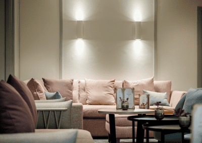 Interior of a hotel pool and spa area, featuring relaxing and comfortable lounge day beds, lounge chairs, and sofas for a calm and serene atmosphere.