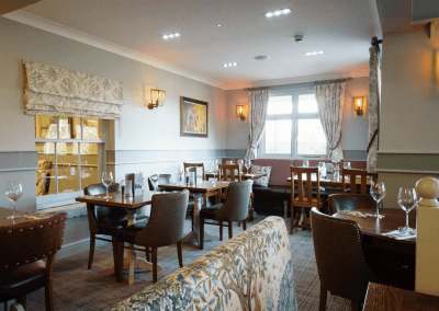 Interior of a family country inn featuring traditional fixed seating, dining and bar furniture, and refurbished pub furniture to enhance the heritage appeal of the pub.