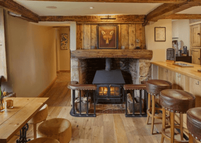 A Grade II listed country pub interior for The Full Moon Inn Somerset, featuring bespoke dining chairs, tub chairs, and fixed seating made by Jameson Seating.