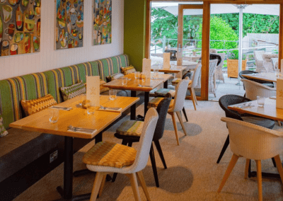 Interior of The Tap & Run pub in Upper Broughton, featuring bespoke bar stools, dining chairs, tables, curtains, and cushions to create a cricket-inspired atmosphere.