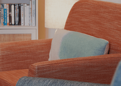 Refurbished common room, featuring durable compact sofas, tub chairs, and dining furniture in uplifting tones.
