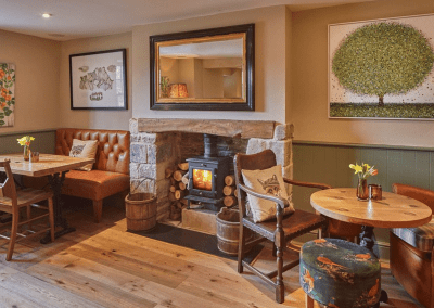A Grade II listed country pub interior, featuring bespoke dining chairs, tub chairs, and fixed seating made by Jameson Seating.