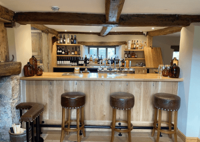 A Grade II listed country pub interior, featuring bespoke dining chairs, tub chairs, and fixed seating made by Jameson Seating.