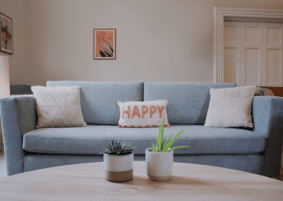 Refurbished common room, featuring durable compact sofas, tub chairs, and dining furniture in uplifting tones.