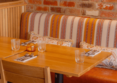 Pub Interior featuring bespoke bar stools, dining chairs, tables, curtains, and cushions to create a cricket-inspired atmosphere.
