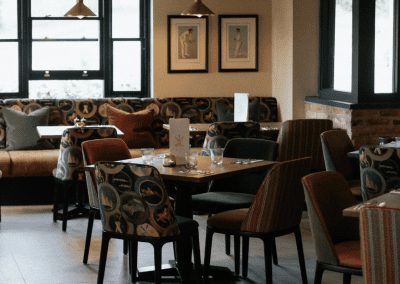 Pub Interior featuring bespoke bar stools, dining chairs, tables, curtains, and cushions to create a cricket-inspired atmosphere.