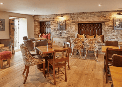 A Grade II listed country pub interior for The Full Moon Inn Somerset, featuring bespoke dining chairs, tub chairs, and fixed seating made by Jameson Seating.