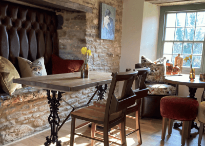 A Grade II listed country pub interior for The Full Moon Inn Somerset, featuring bespoke dining chairs, tub chairs, and fixed seating made by Jameson Seating.