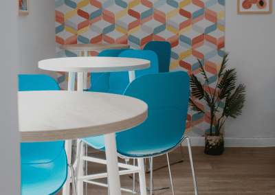 Refurbished common room, featuring durable compact sofas, tub chairs, and dining furniture in uplifting tones.
