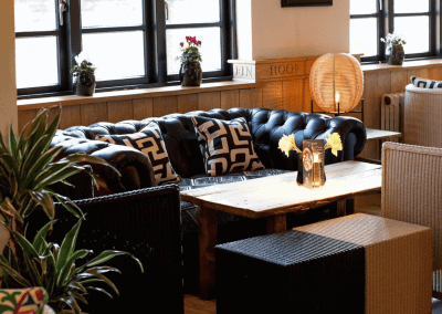A stylish country pub interior, featuring bespoke dining chairs, tub chairs, and fixed seating made by Jameson Seating.