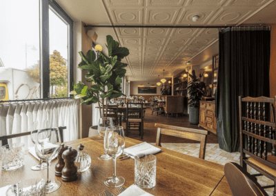 Interior of a stylish public house, featuring contemporary partition curtains for separate dining and gaming room spaces, and café curtains for a warm and contemporary feel.