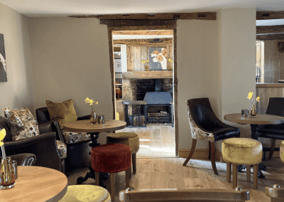 A Grade II listed country pub interior, featuring bespoke dining chairs, tub chairs, and fixed seating made by Jameson Seating.