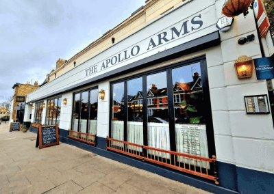 Interior of a stylish public house, featuring contemporary partition curtains for separate dining and gaming room spaces, and café curtains for a warm and contemporary feel.