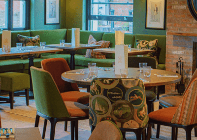 Interior of The Tap & Run pub in Upper Broughton, featuring bespoke bar stools, dining chairs, tables, curtains, and cushions to create a cricket-inspired atmosphere.