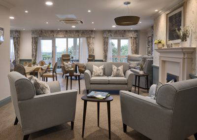 Interior picture of a residential care home, featuring calming and comfortable furniture in a range of rooms, to support senior living.