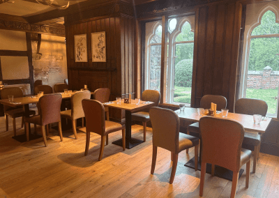 Bespoke pub furniture and soft furnishings featuring comfortable seating, dining tables, and curtains designed to complement the venue’s warm, rustic interior.