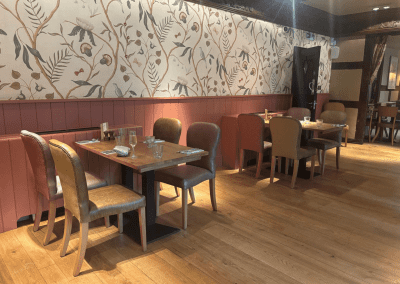 Bespoke pub furniture and soft furnishings featuring comfortable seating, dining tables, and curtains designed to complement the venue’s warm, rustic interior.